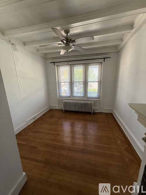 A room with wooden floors and a ceiling fan.