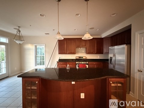 A kitchen with brown cabinets and a black countertop.