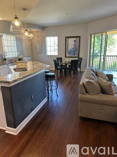 A kitchen with a bar and a couch in the living room.