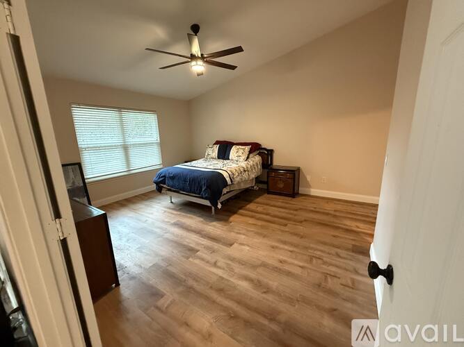 A bedroom with a bed, dresser, and ceiling fan.