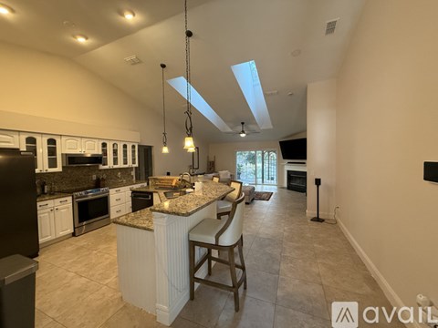 A kitchen with a large island and pendant lights.