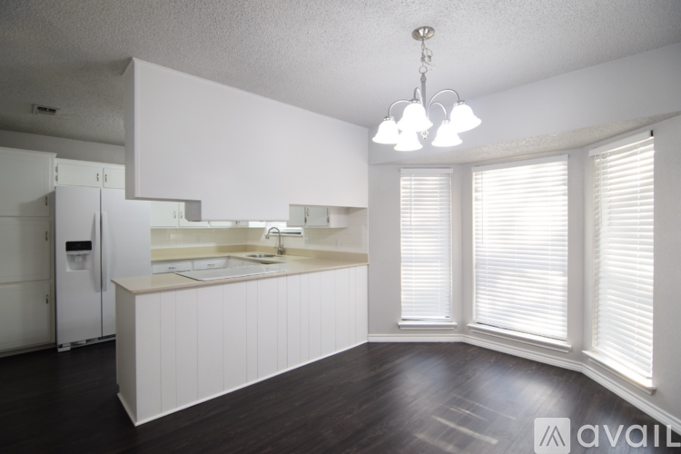 A kitchen with white cabinets and a white refrigerator.