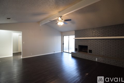 A living room with a fireplace and a ceiling fan.