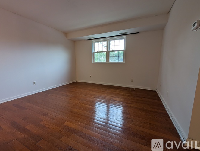 A room with wooden flooring and a window.