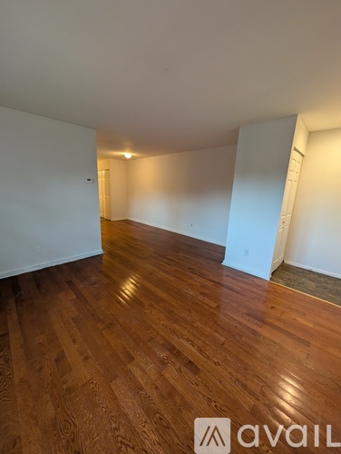 A room with wooden flooring and white walls.