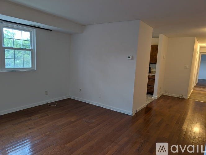 A room with wooden flooring and a window.