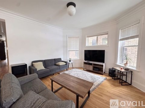 A living room with a grey couch and a wooden coffee table.