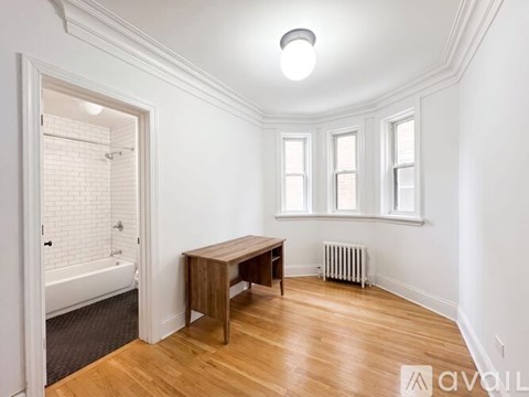 A room with a wooden table and a bathtub in the corner.