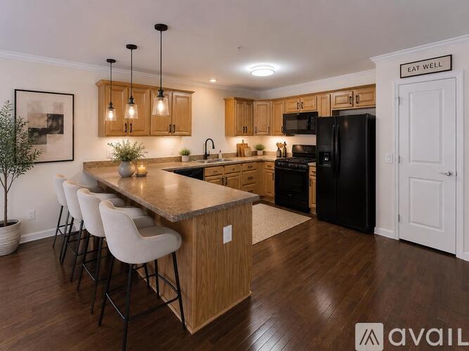 A kitchen with a long island and bar stools.