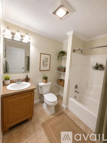 A bathroom with a toilet, sink, and shower.