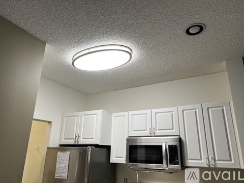 A kitchen with white cabinets and a microwave oven.