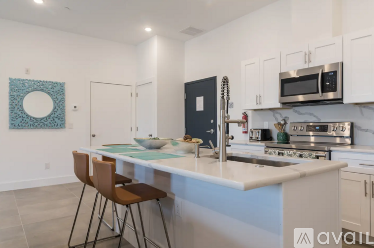 A kitchen with a white countertop and a blue backsplash.