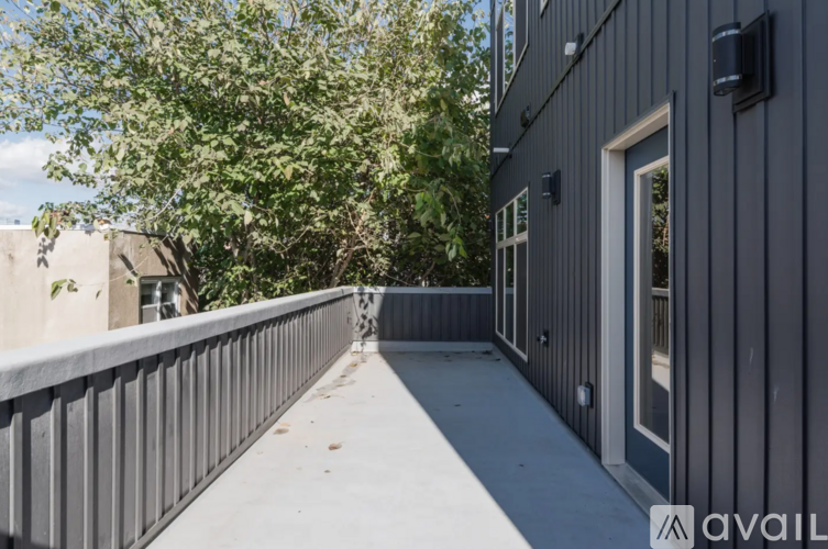 A balcony with a metal railing and a grey building in the background.