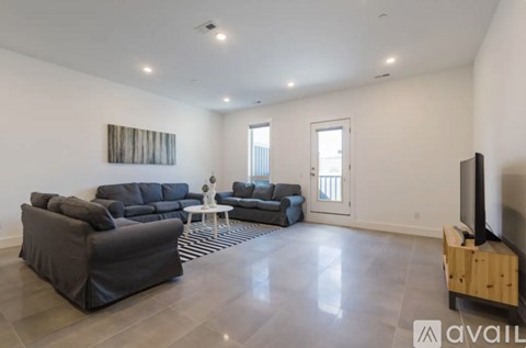 A living room with a grey sofa set and a television.