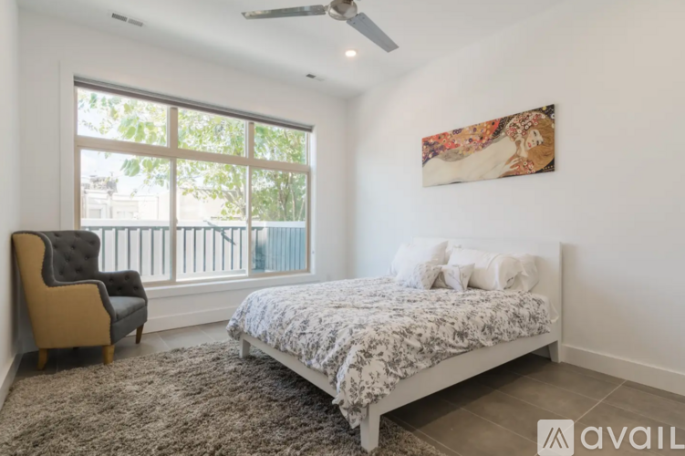 A bedroom with a large bed and a chair.