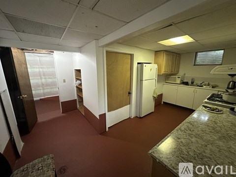 A kitchen with brown flooring and white appliances.
