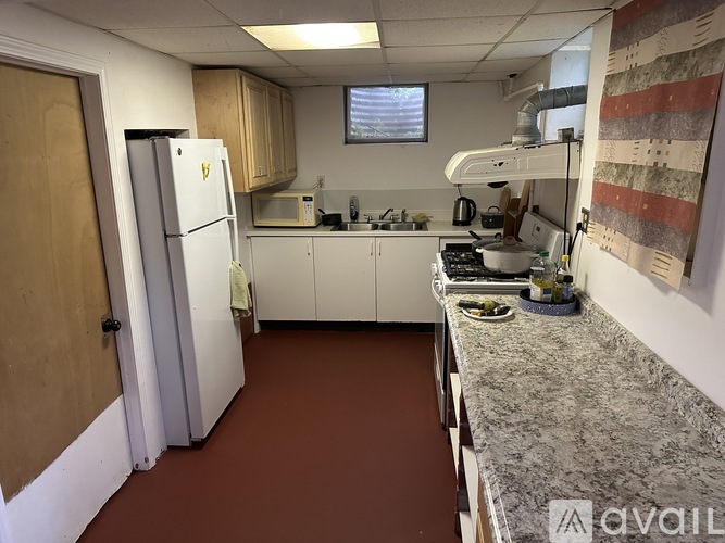 A kitchen with a refrigerator, microwave, and oven.
