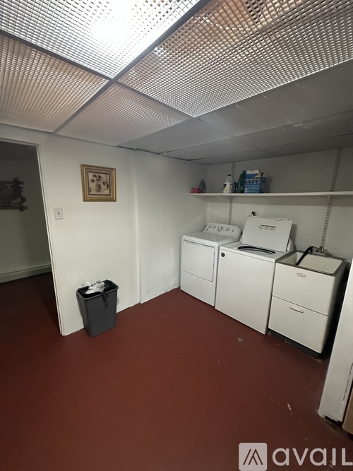 A room with a brown floor and white cabinets.