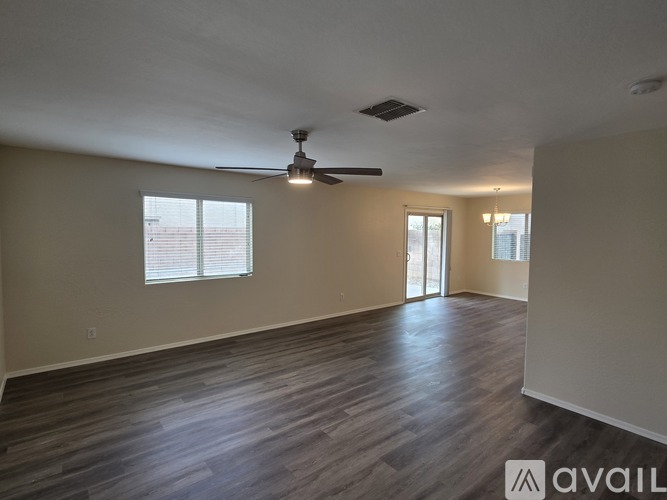 A spacious room with a ceiling fan and sliding glass doors.