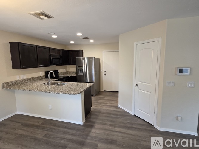 A kitchen with a granite countertop and stainless steel appliances.