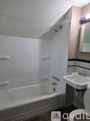 A bathroom with a white tub, sink, and mirror.