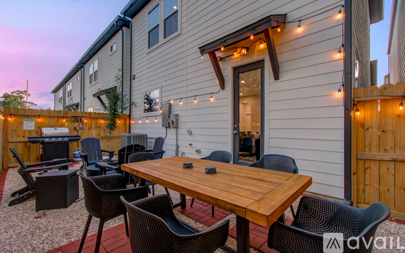 A patio with a table and chairs is set up outside a house.