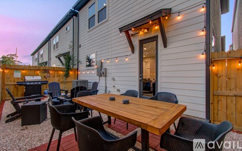 A patio with a table and chairs is set up outside a house.