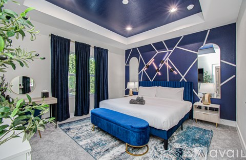 A bedroom with a large bed and a mirror on the wall.