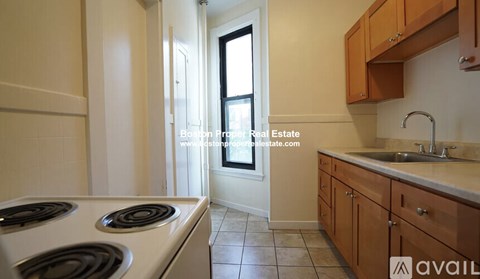 A kitchen with a stove top oven and a sink.