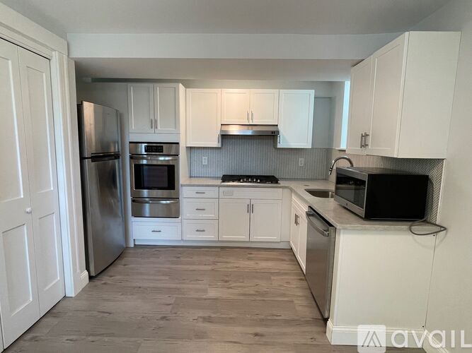 A kitchen with white cabinets and stainless steel appliances.