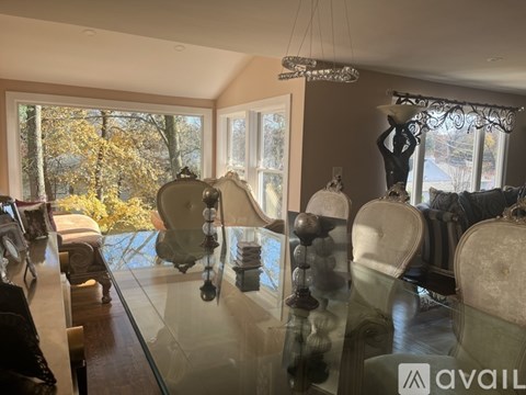 A modern dining room with a glass table and chairs.
