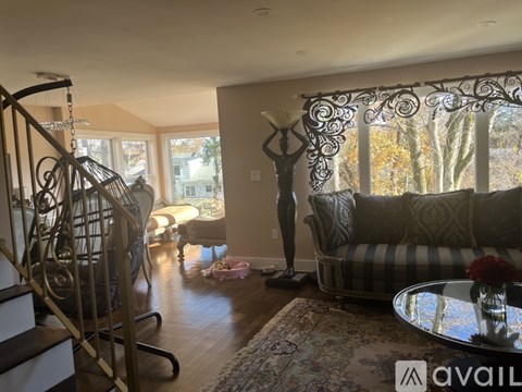 A living room with a striped couch and a metal sculpture.