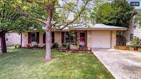 A house with a red door and a tree in front.
