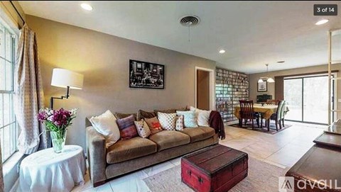 A living room with a couch, a coffee table, and a painting on the wall.