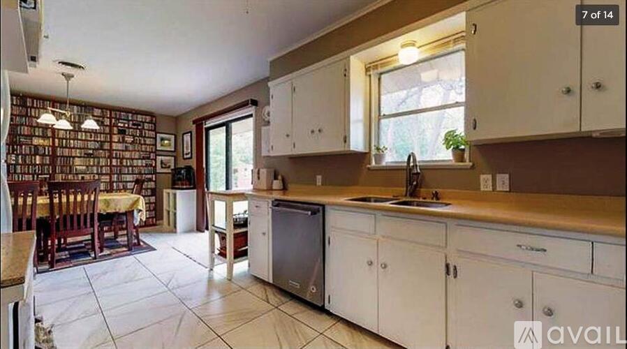 A kitchen with white cabinets and a tiled floor.