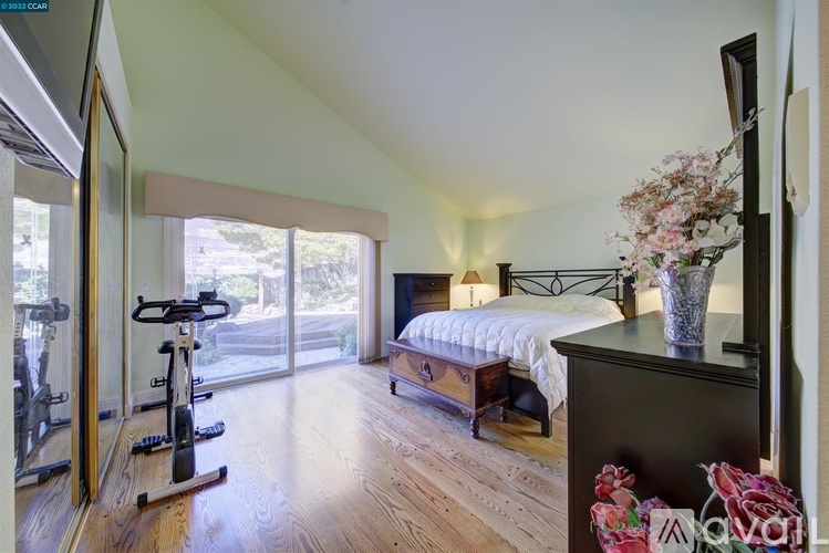 A bedroom with a bed, a dresser, and a mirror.