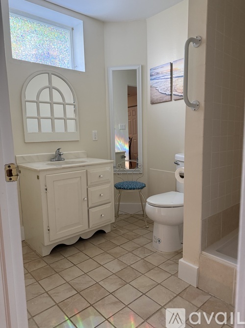 A bathroom with a toilet, sink, and a window.