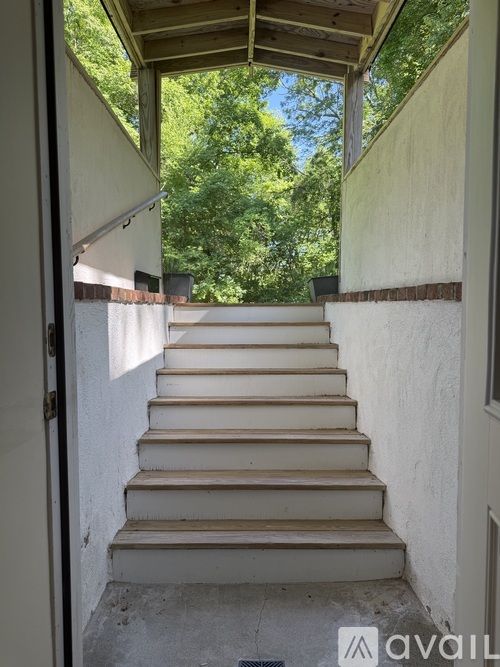 A set of stairs leading up to a door with a view of trees in the background.