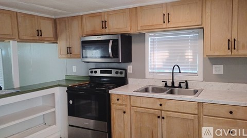 A kitchen with wooden cabinets and a black stove top oven.