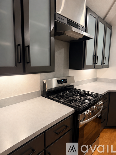 A kitchen with a stove top oven and cabinets.