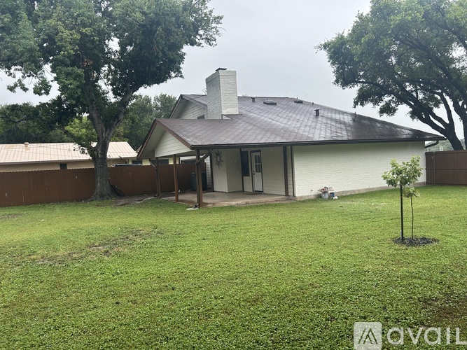 A house with a brown roof and a tree in front of it.