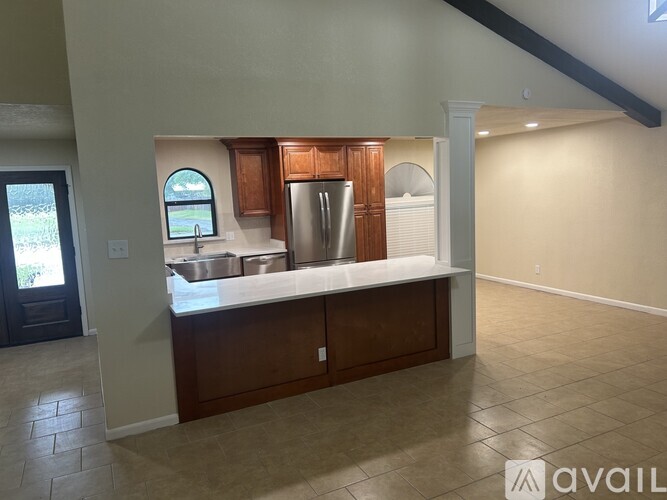 A kitchen with a sink, refrigerator, and cabinets.