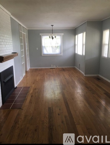 A room with wooden floors and a fireplace.