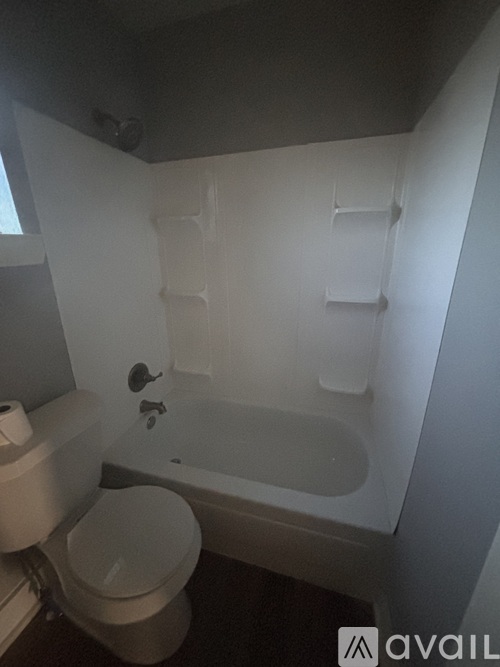 A white toilet and bathtub in a small bathroom.