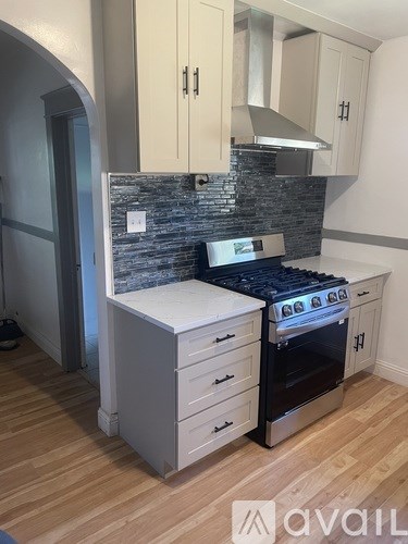 A kitchen with a black stove top oven and a white microwave.