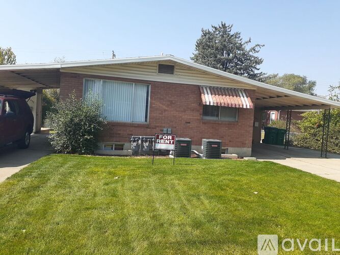 A house with a red brick exterior and a white roof is for rent.