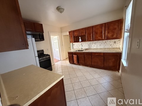 A kitchen with brown cabinets and a white refrigerator.