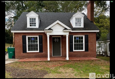 A brick house with a black window and a white door.