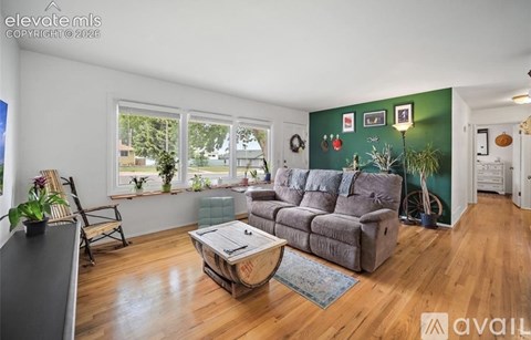 A living room with a grey couch and wooden floors.
