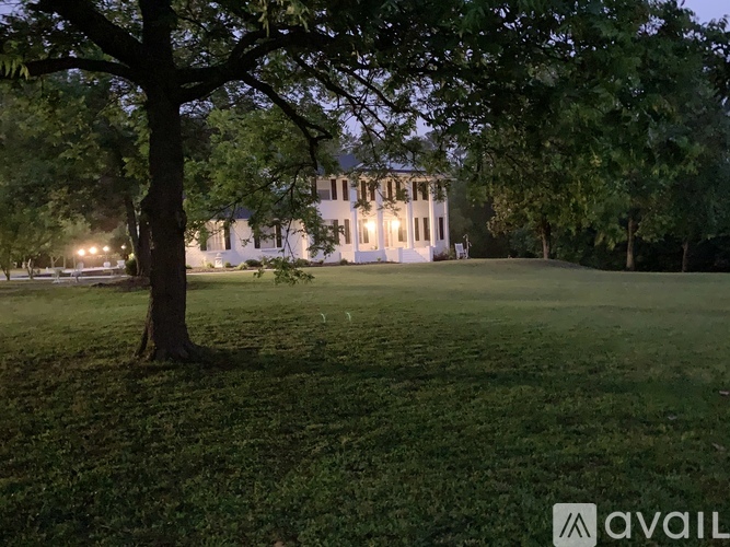 A large white house with a tree in front of it.